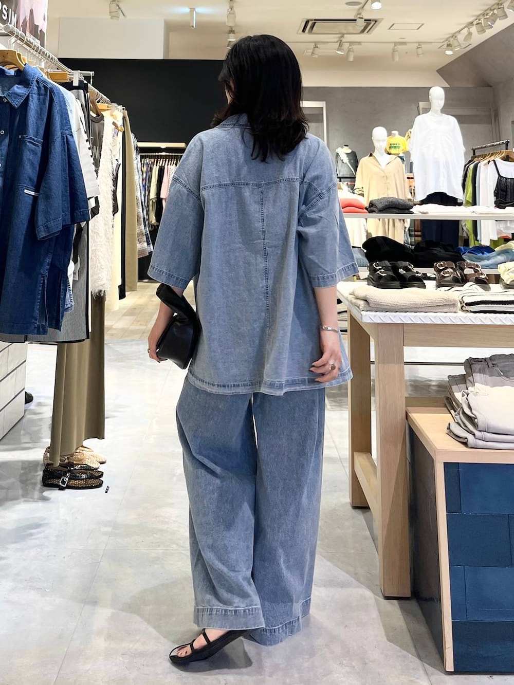 ブルー系のシャツ/ブラウス、ホワイト系のタンクトップ、ブルー系のデニムパンツを着用したレディースの春コーディネートの3枚目の写真