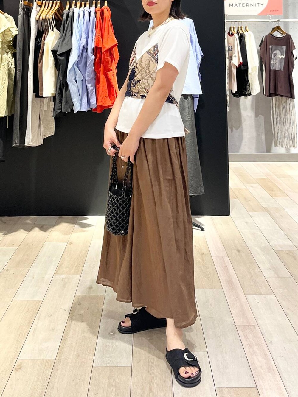 ブラウン系のその他パンツ、ブラック系のサンダル、ブラック系のハンドバッグを着用したレディースの夏コーディネートの4枚目の写真