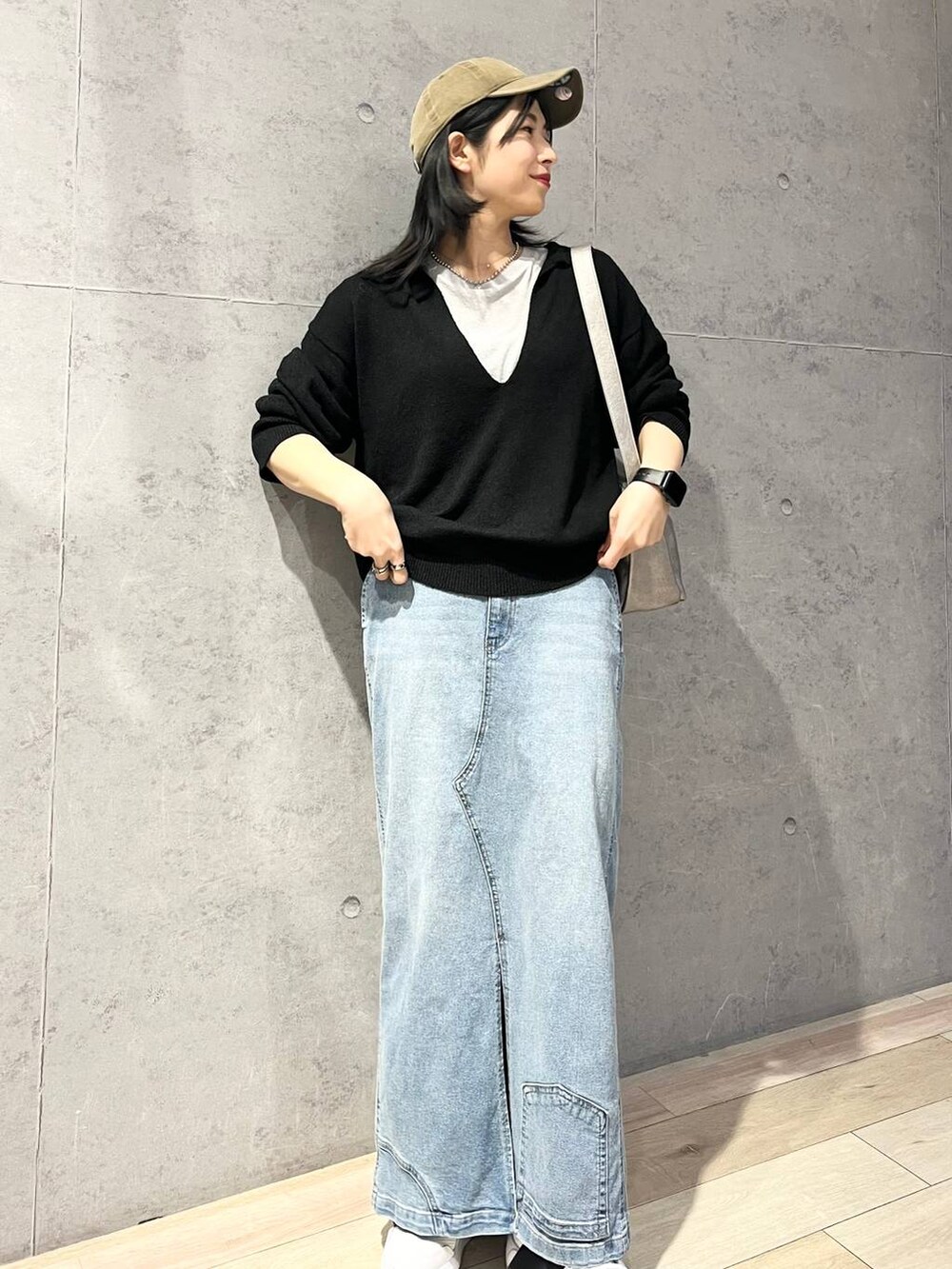 グレー系のTシャツ/カットソー、ブルー系のデニムスカート、ブラック系のニット/セーターを着用したレディースの冬コーディネートの6枚目の写真