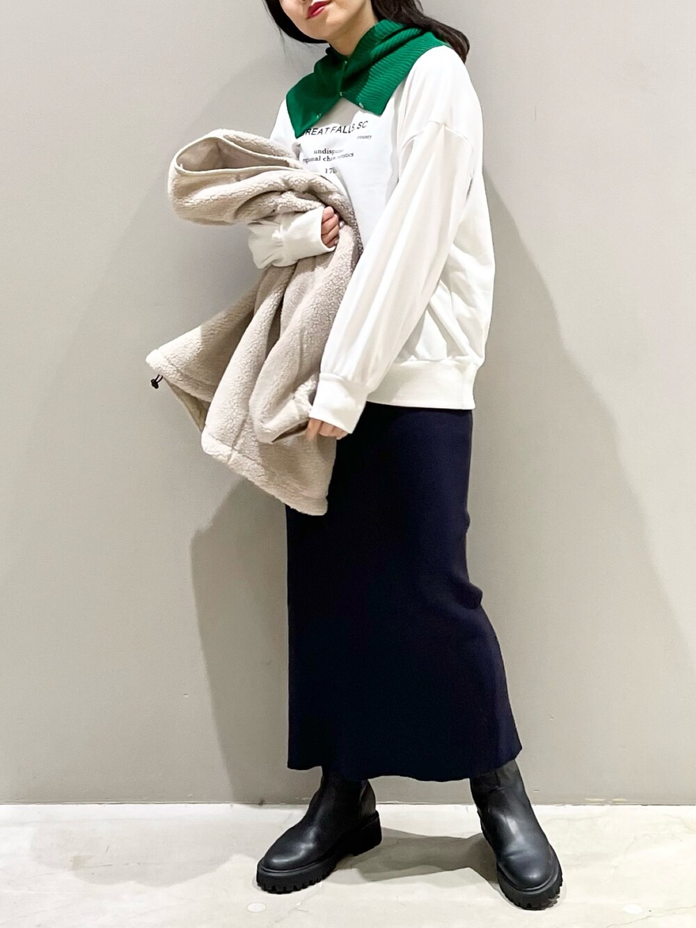ブルー系のスカート、ブラック系のブーツ、ホワイト系のトップスを着用したレディースの秋コーディネートの2枚目の写真