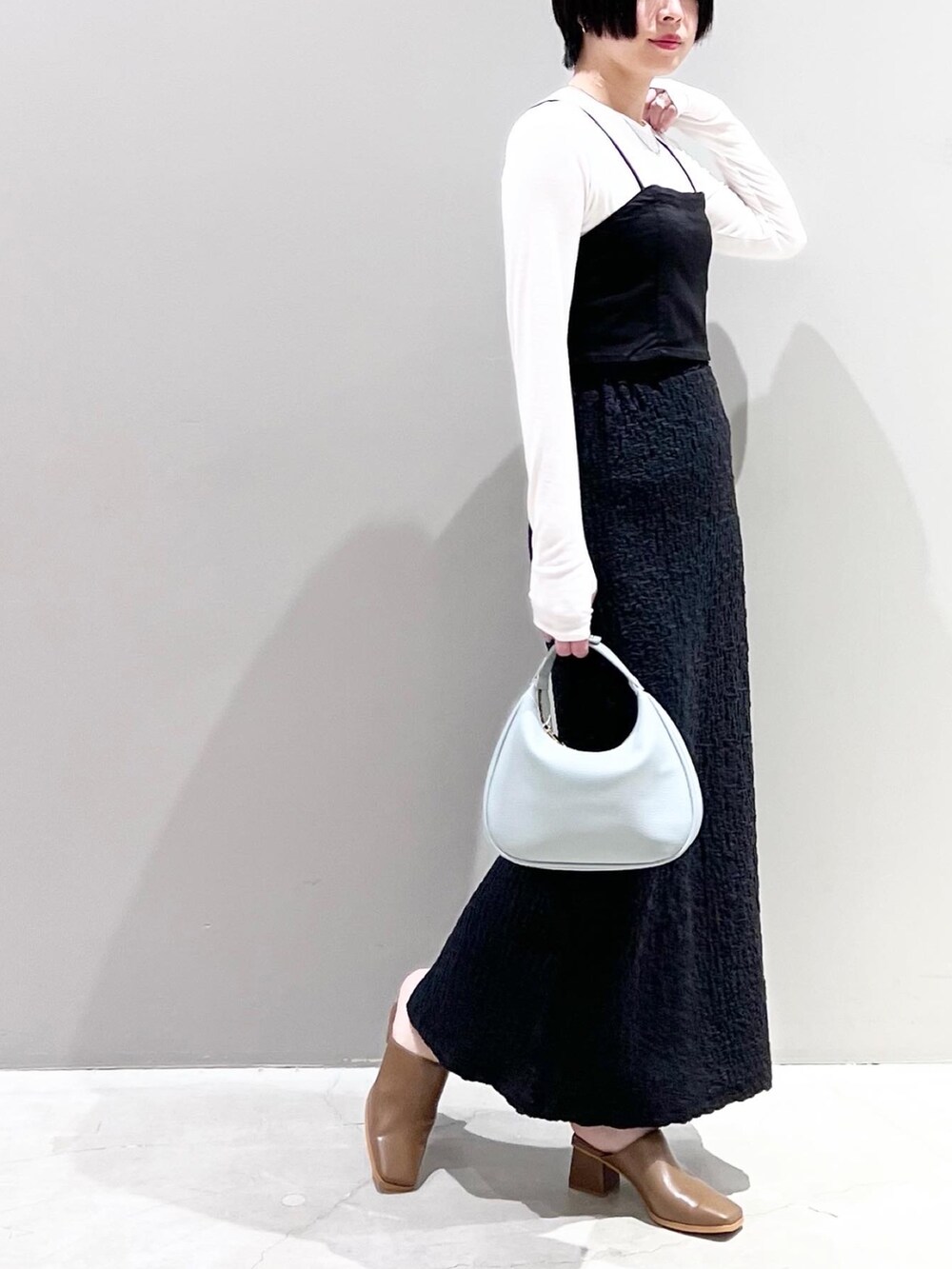 ブラウン系のサンダル、ブルー系のショルダーバッグ、ホワイト系のTシャツ/カットソーを着用したレディースの春コーディネートの2枚目の写真