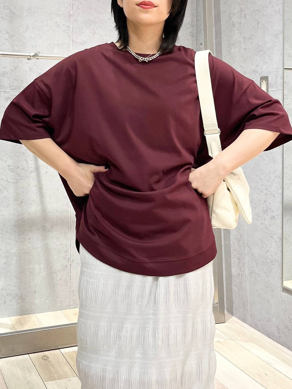 ホワイト系のショルダーバッグ、ブラック系のサンダル、レッド系のTシャツ/カットソーを着用したレディースの夏コーディネートの7枚目の写真