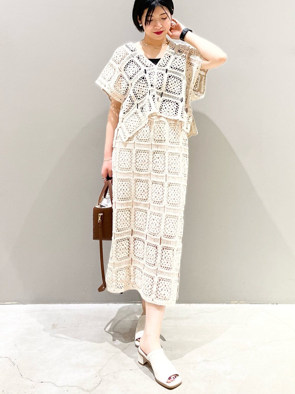 ホワイト系のスカート、ホワイト系のTシャツ/カットソー、ホワイト系のサンダルを着用したレディースの夏コーディネートの4枚目の写真