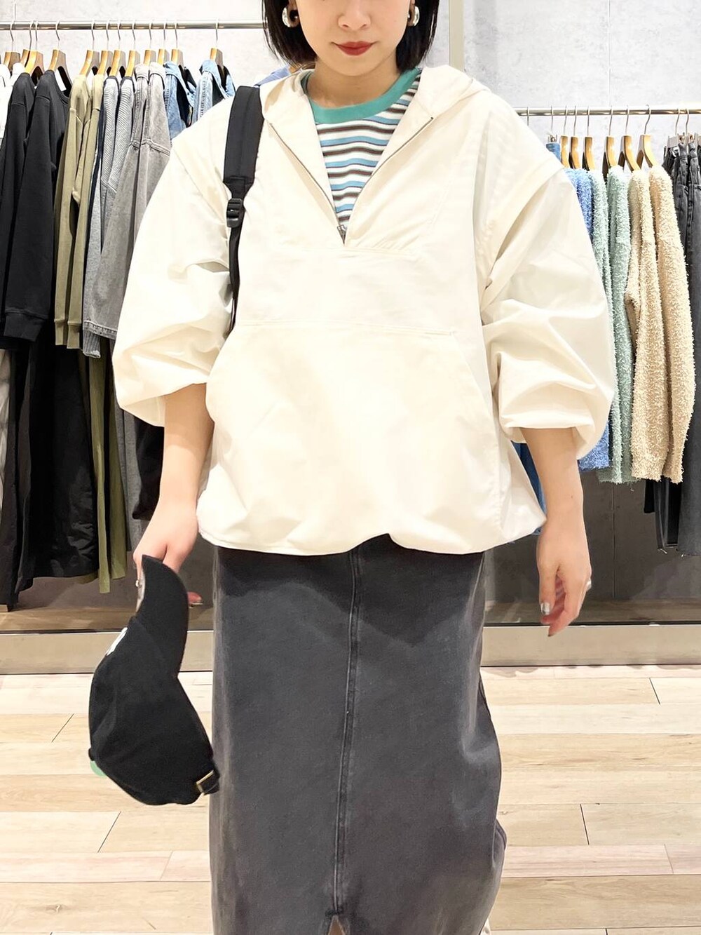 ブラック系のショルダーバッグ、ホワイト系のTシャツ/カットソー、ブラック系のスカートを着用したレディースの春コーディネートの3枚目の写真