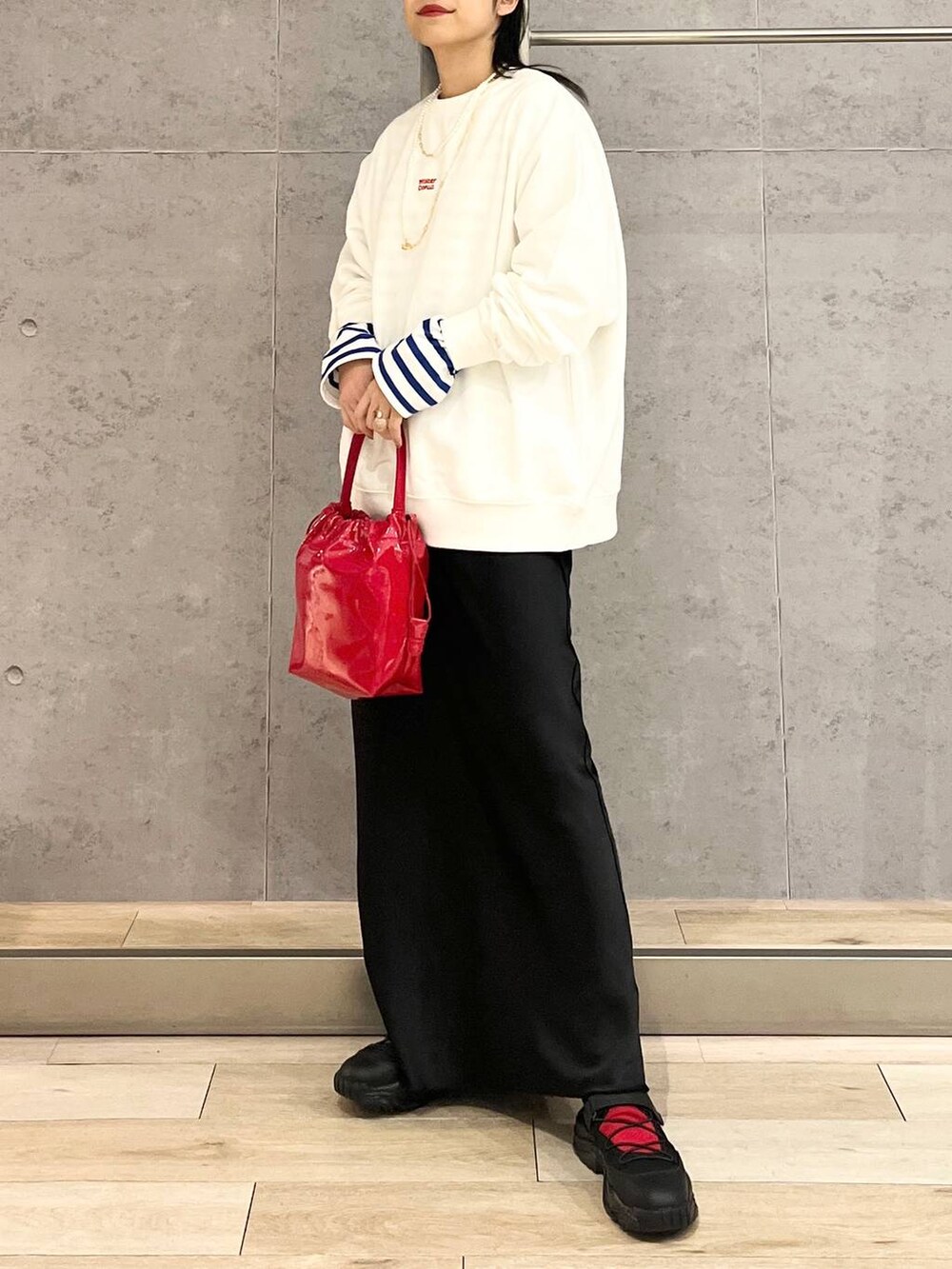 ブラック系のスカート、ブラック系のスニーカー、ホワイト系のスウェットを着用したレディースの冬コーディネートの6枚目の写真