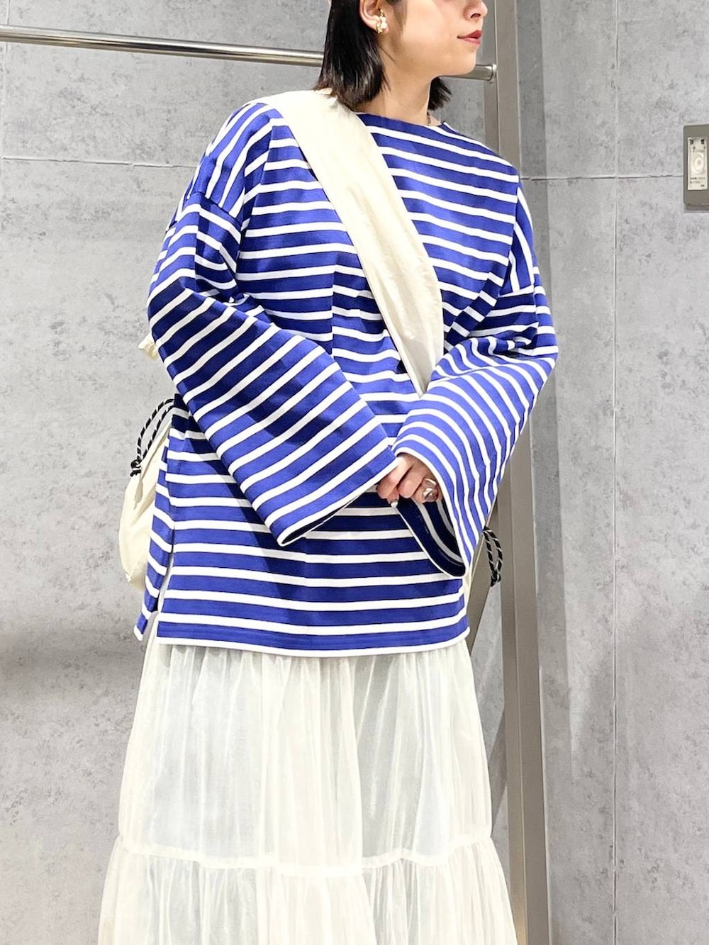 ホワイト系のスカート、パープル系のTシャツ/カットソー、ブルー系のデニムパンツを着用したレディースの冬コーディネートの8枚目の写真