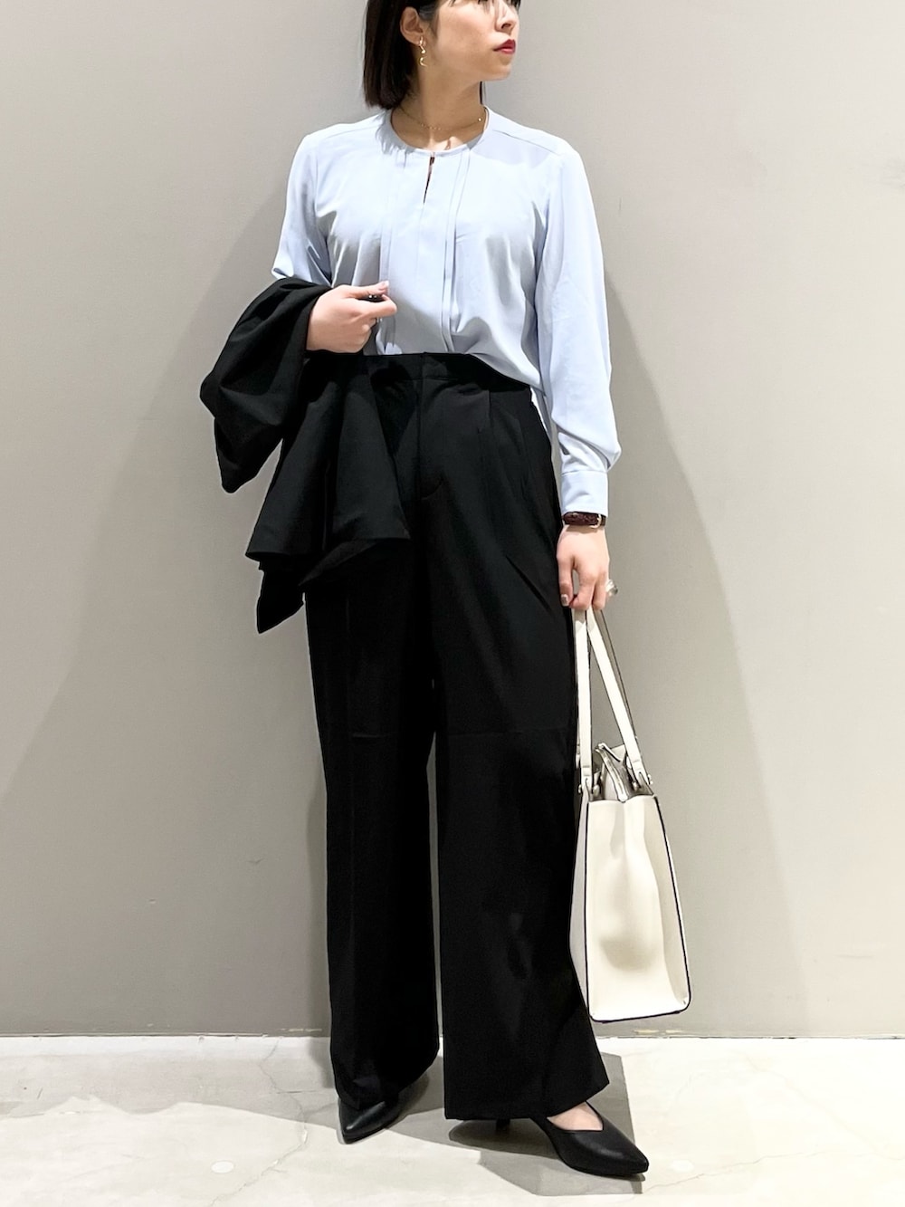 ブラック系のパンツ、ホワイト系のトートバッグ、ブラック系のパンプスを着用したレディースの冬コーディネートの4枚目の写真