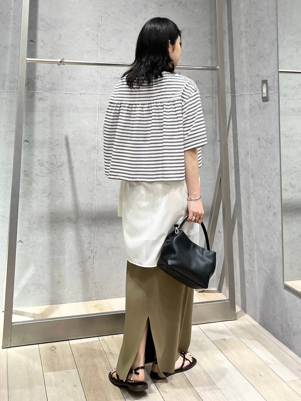 グリーン系のスカート、ホワイト系のTシャツ/カットソー、ホワイト系のシャツ/ブラウスを着用したレディースの春コーディネートの4枚目の写真