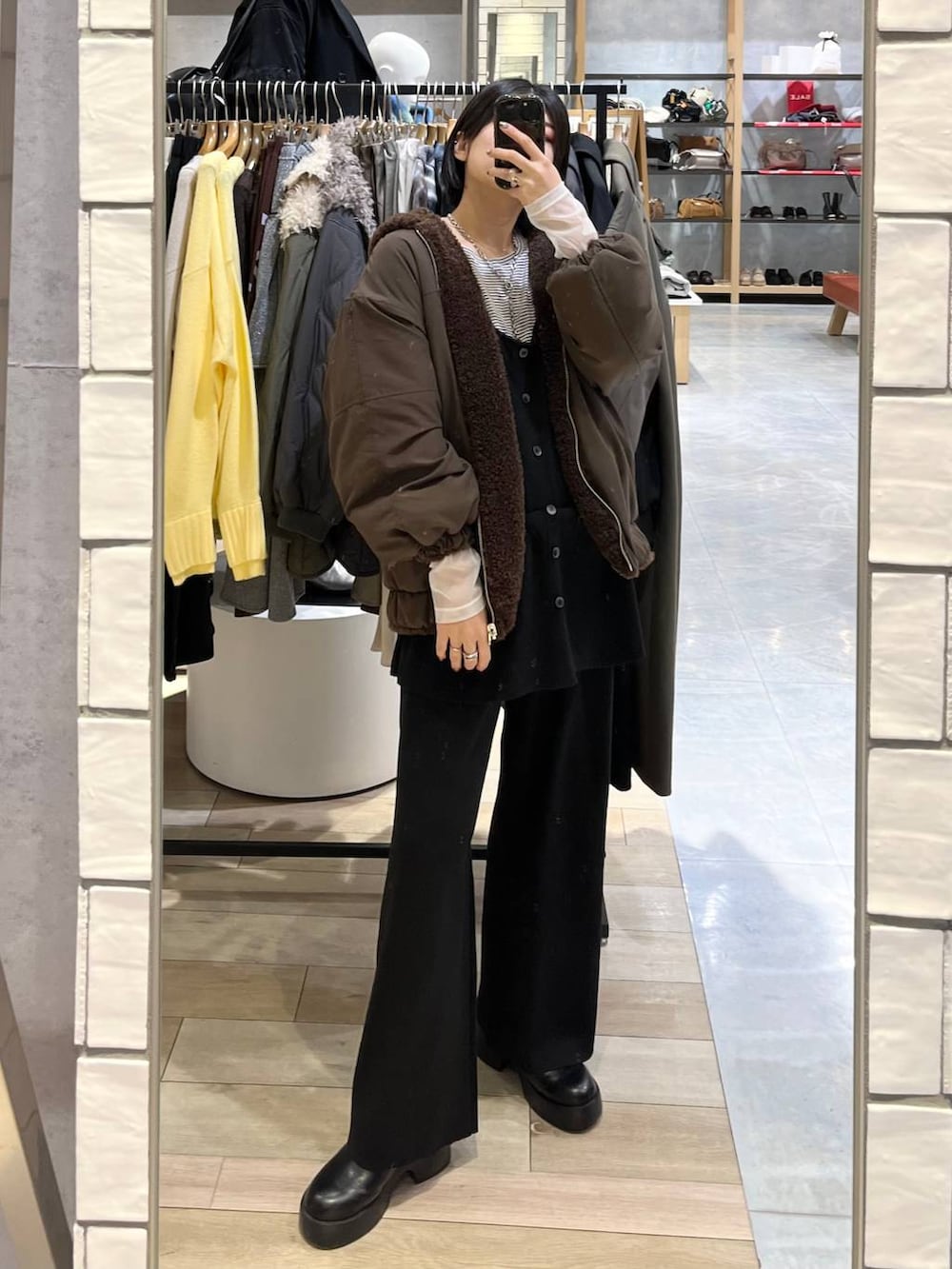 ホワイト系のTシャツ/カットソー、ブラウン系のブルゾン、ブラック系のその他シューズを着用したレディースの冬コーディネートの4枚目の写真