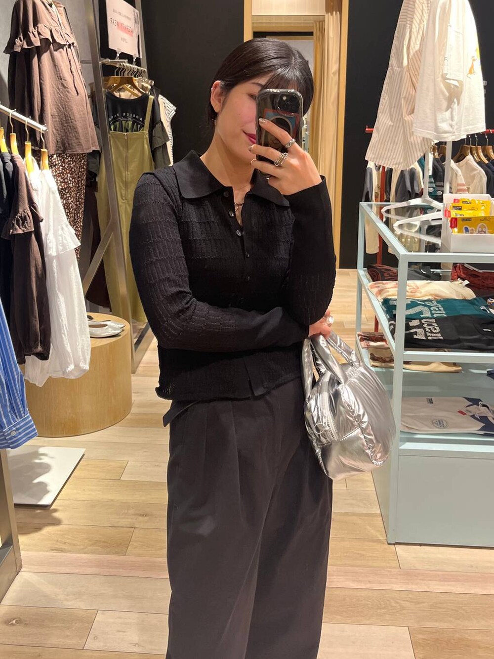 ブラック系のニット/セーター、グレー系のチノパンツ、グレー系のネックレスを着用したレディースの秋コーディネートの2枚目の写真