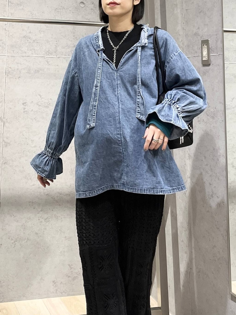 ブラック系のブーツ、ブラック系のボストンバッグ、ブラック系のその他パンツを着用したレディースの冬コーディネートの3枚目の写真