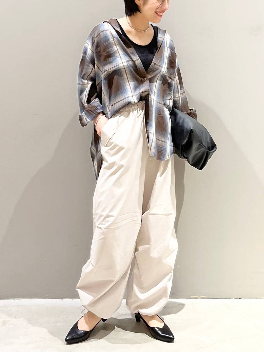 ブラウン系のシャツ/ブラウス、ホワイト系のその他パンツ、ブラック系のハンドバッグを着用したレディースの夏コーディネートの4枚目の写真