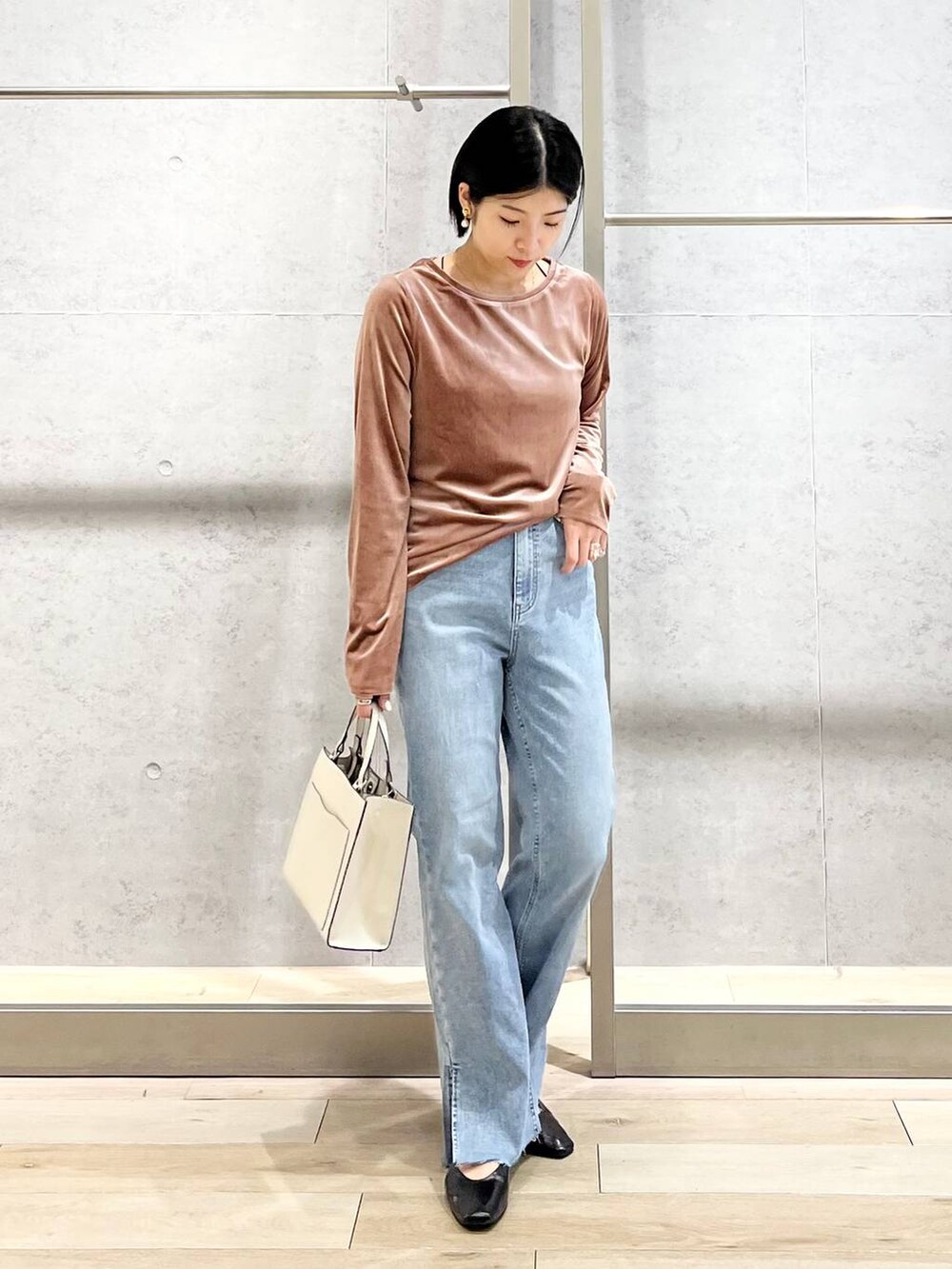 ブラック系のパンプス、ブルー系のデニムパンツ、ホワイト系のショルダーバッグを着用したレディースの秋コーディネートの8枚目の写真