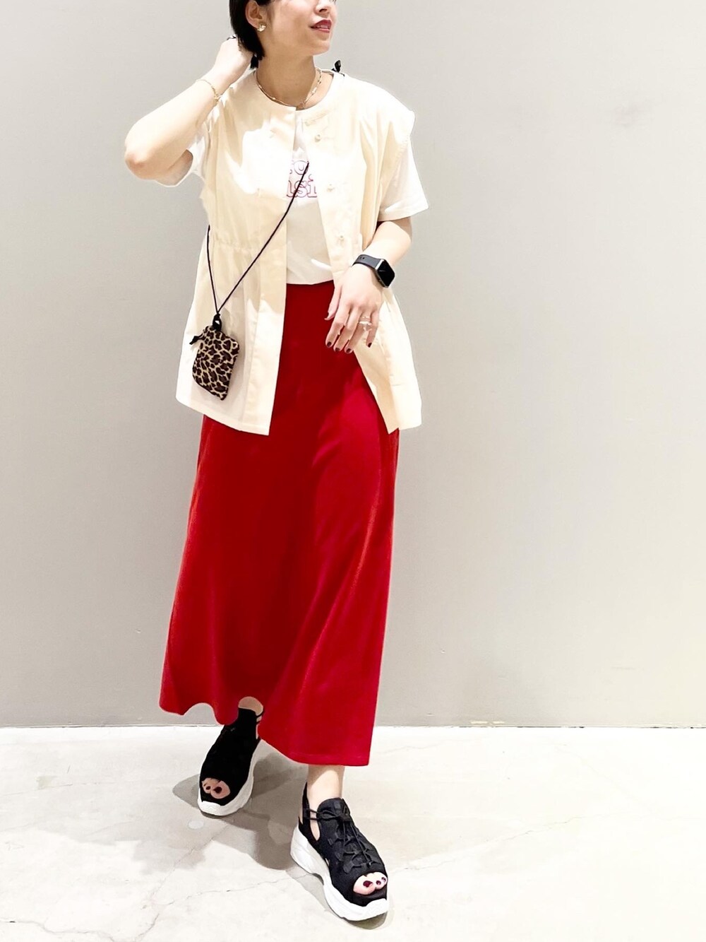 レッド系のスカート、ブラック系のサンダル、ホワイト系のシャツ/ブラウスを着用したレディースの夏コーディネートの3枚目の写真
