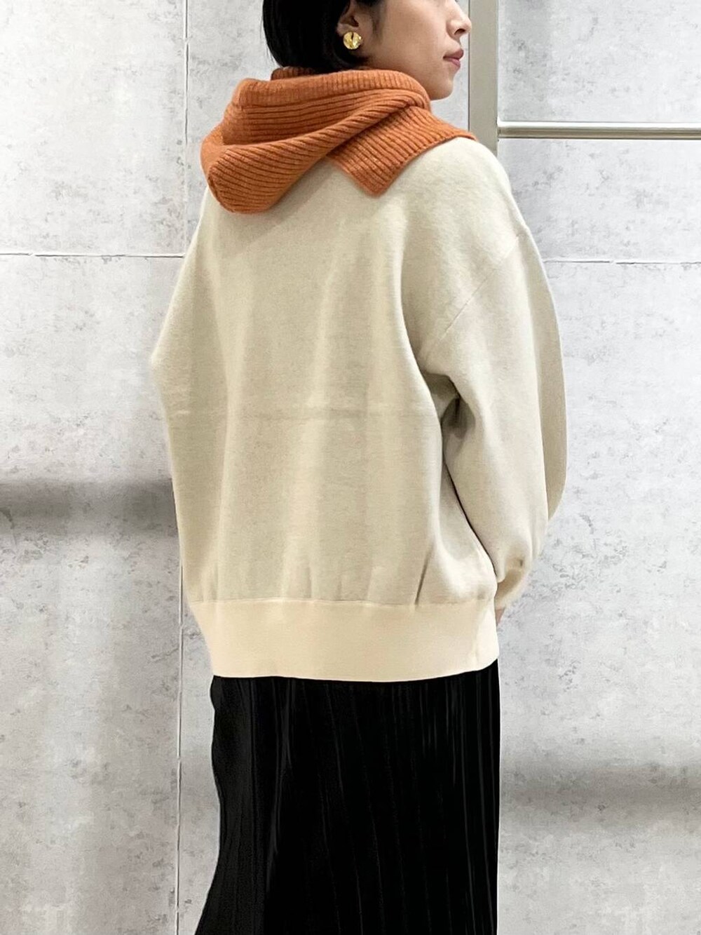 ブラック系のショルダーバッグ、ブラック系のブーツ、ホワイト系のニット/セーターを着用したレディースの秋コーディネートの6枚目の写真