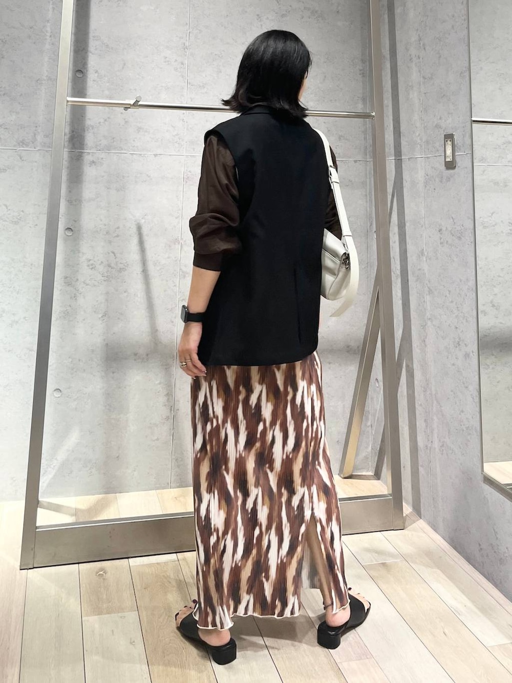 ブラウン系のシャツ/ブラウス、ブラック系のサンダル、グレー系のショルダーバッグを着用したレディースの秋コーディネートの4枚目の写真