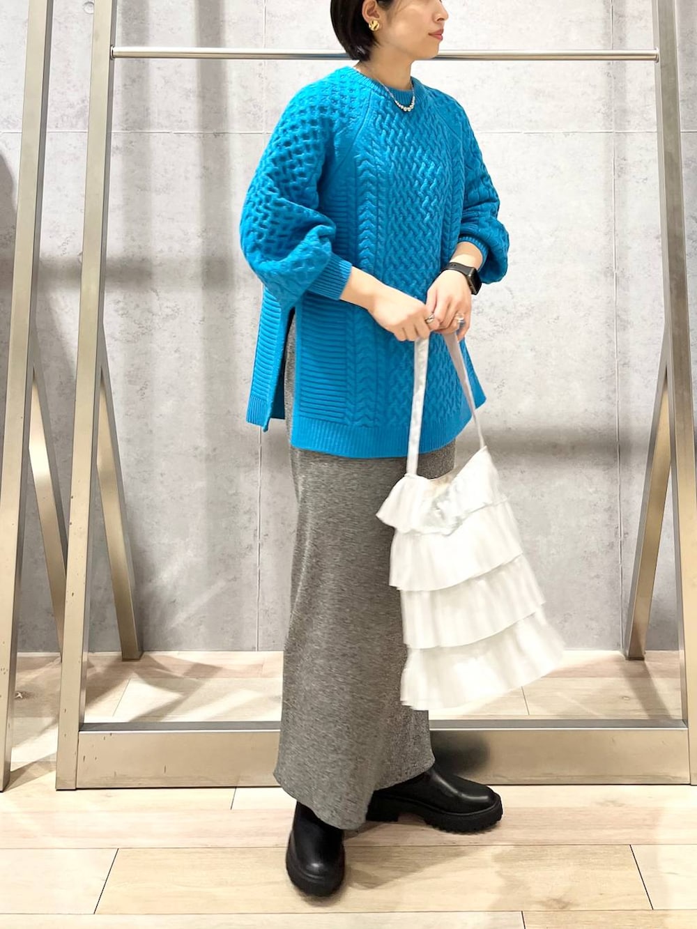 ブラック系のブーツ、シルバー系のトートバッグ、ブルー系のその他トップスを着用したレディースの秋コーディネートの4枚目の写真