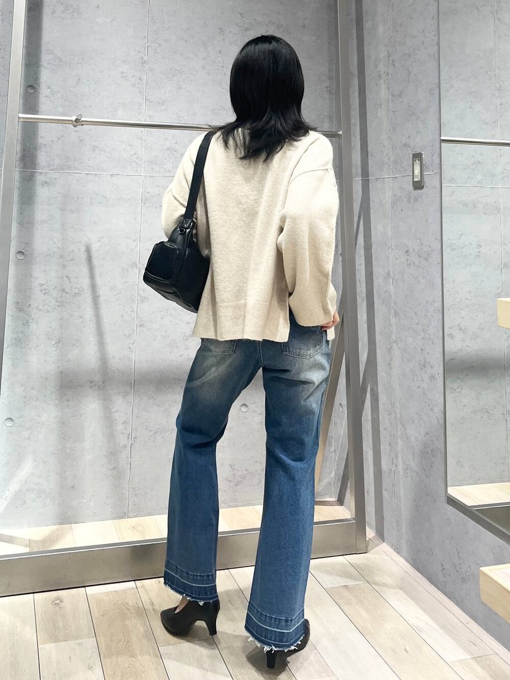 ブラック系のパンプス、ブラック系のショルダーバッグ、ベージュ系のニット/セーターを着用したレディースの冬コーディネートの4枚目の写真