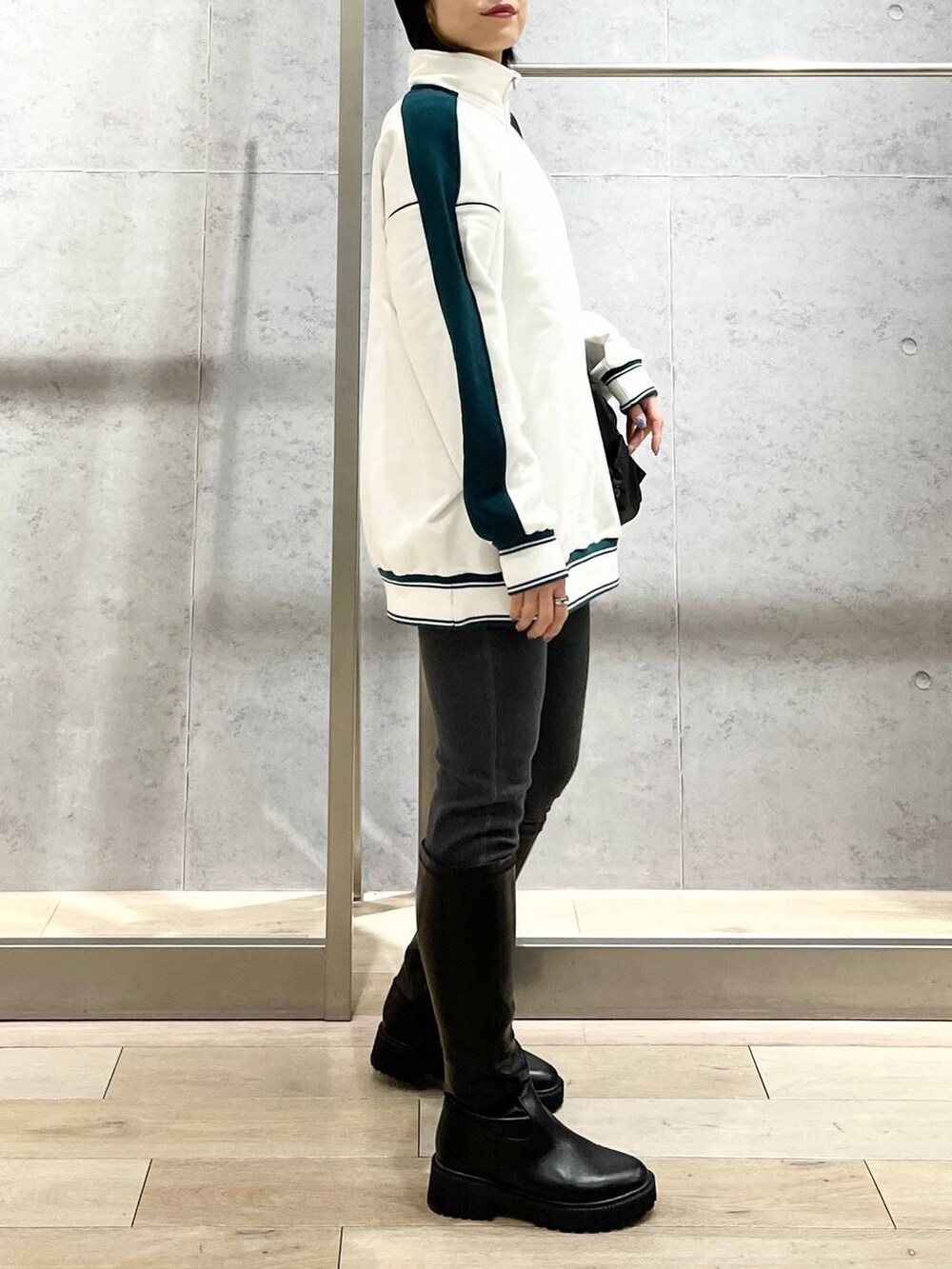 ホワイト系のTシャツ/カットソー、ブラック系のブーツ、グレー系のデニムパンツを着用したレディースの冬コーディネートの5枚目の写真