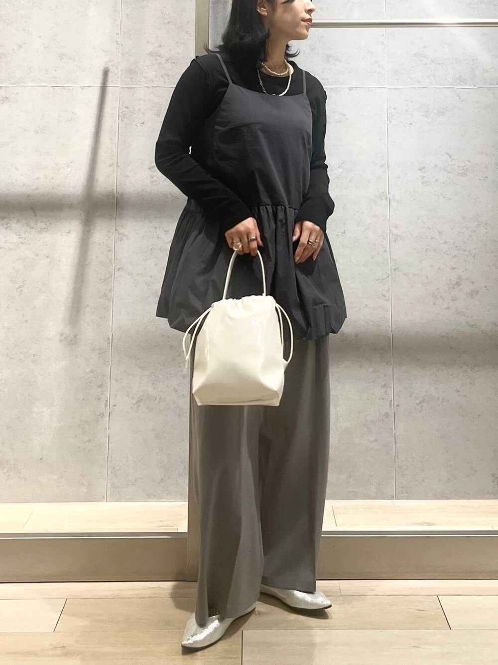 シルバー系のパンプス、ホワイト系のショルダーバッグ、グレー系のその他パンツを着用したレディースの春コーディネートの6枚目の写真