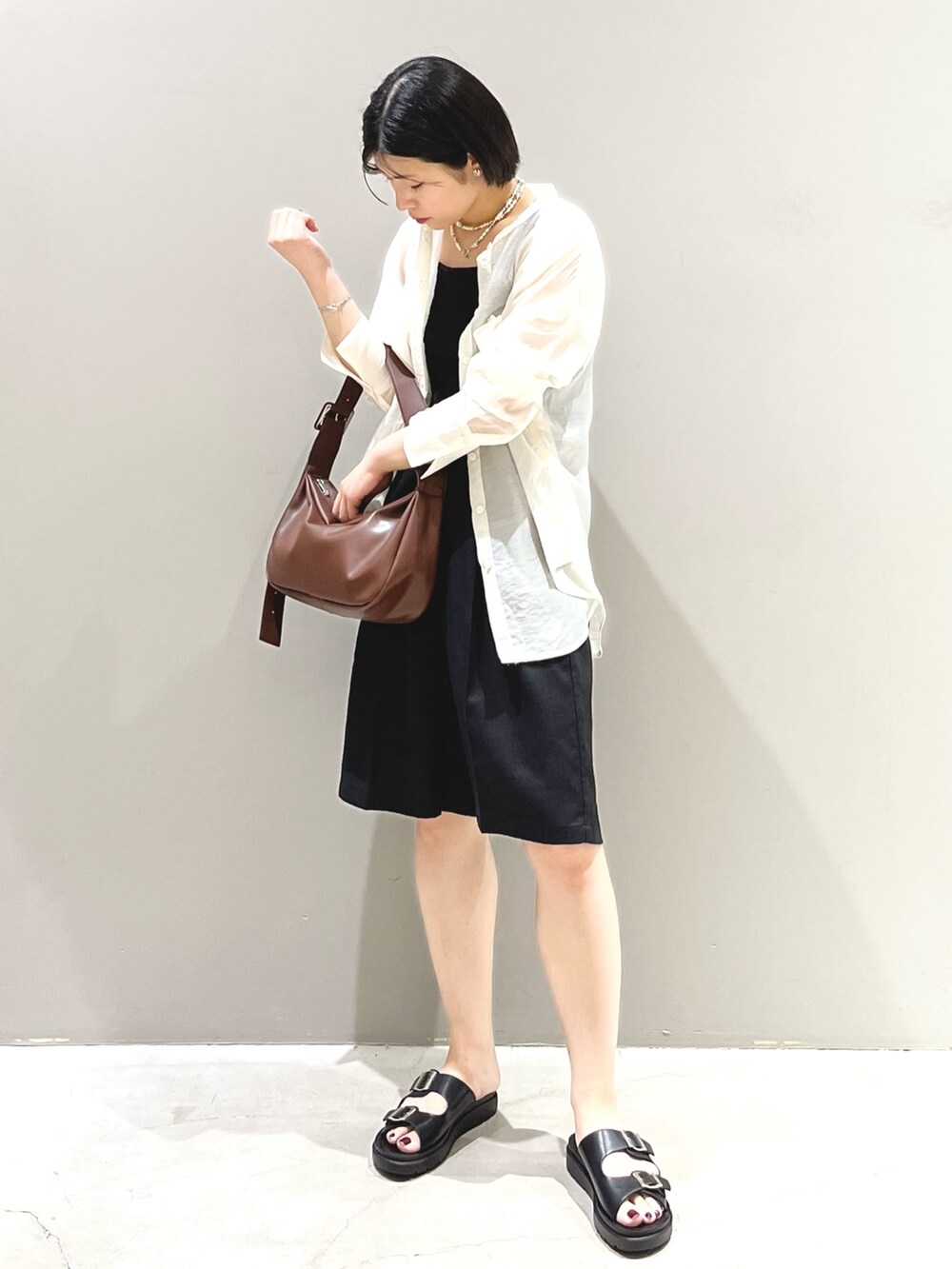 ブラウン系のショルダーバッグ、ブラック系のサンダル、ブラック系のその他パンツを着用したレディースの夏コーディネートの3枚目の写真