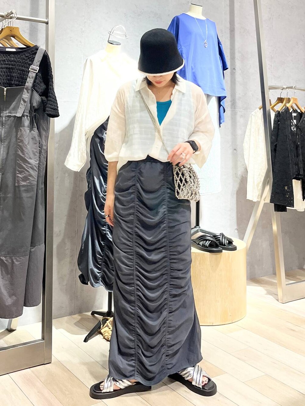 グレー系のスカート、シルバー系のサンダル、ブルー系のタンクトップを着用したレディースの夏コーディネートの5枚目の写真