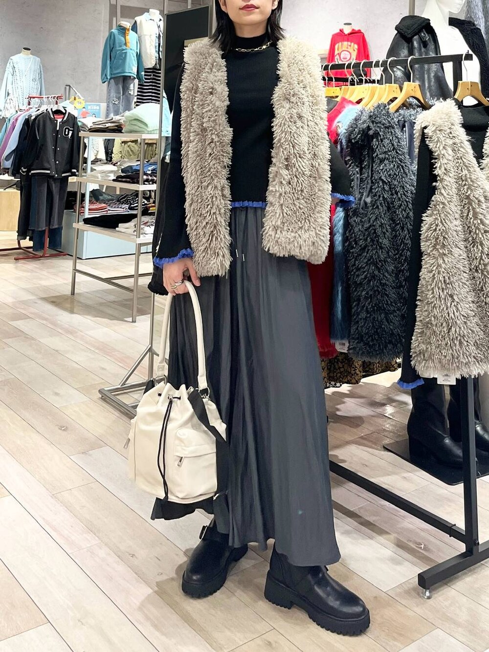 ホワイト系のショルダーバッグ、グレー系のその他パンツ、ブラック系のブーツを着用したレディースの秋コーディネートの6枚目の写真