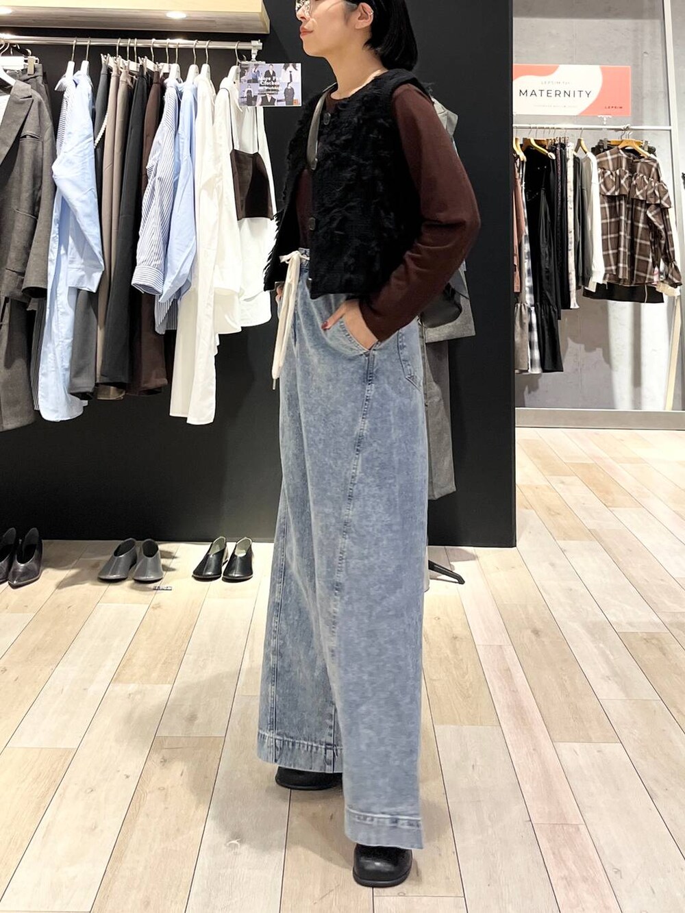 ブルー系のデニムパンツ、ブラック系のショルダーバッグ、ブラック系のその他シューズを着用したレディースの秋コーディネートの2枚目の写真