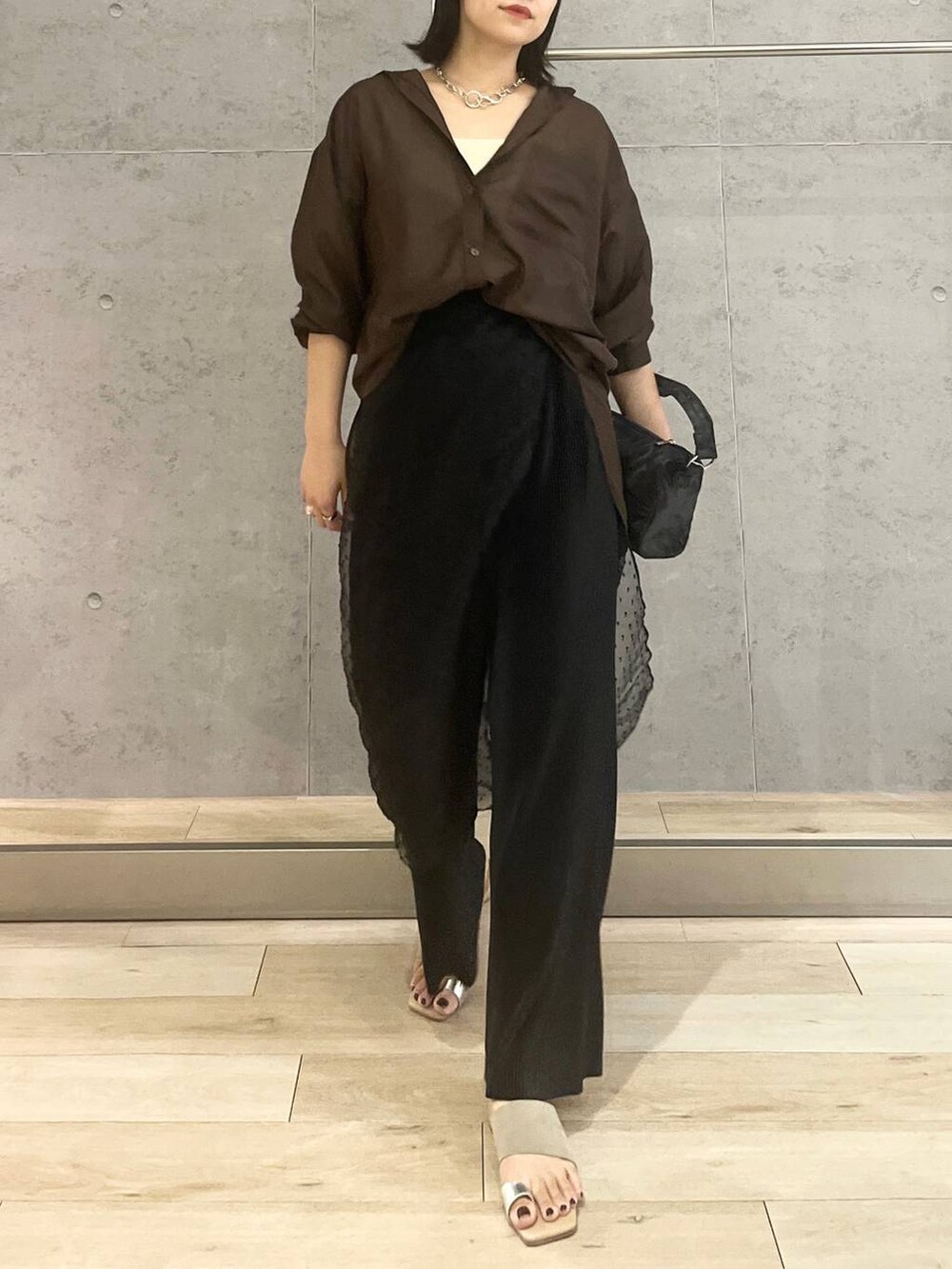 ホワイト系のタンクトップ、ブラック系のハンドバッグ、ブラック系のその他パンツを着用したレディースの夏コーディネートの7枚目の写真