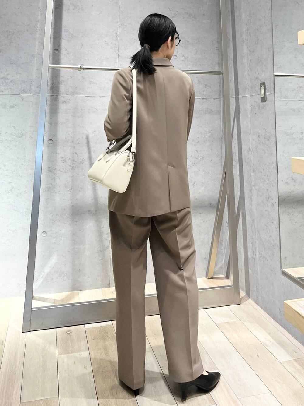 ブラック系のニット/セーター、ブラウン系のスーツパンツ、ブラック系のパンプスを着用したレディースの冬コーディネートの4枚目の写真