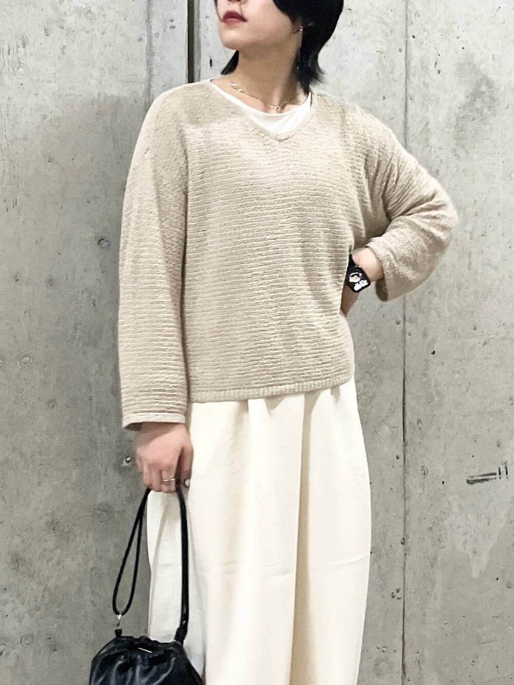 ブラック系のショルダーバッグ、ブラック系のサンダル、ホワイト系のTシャツ/カットソーを着用したレディースの春コーディネートの6枚目の写真