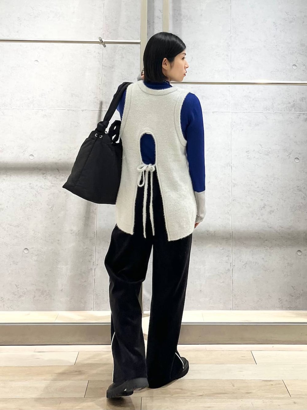 ブラック系のブーツ、ブルー系のニット/セーター、ブラック系のその他パンツを着用したレディースの冬コーディネートの2枚目の写真