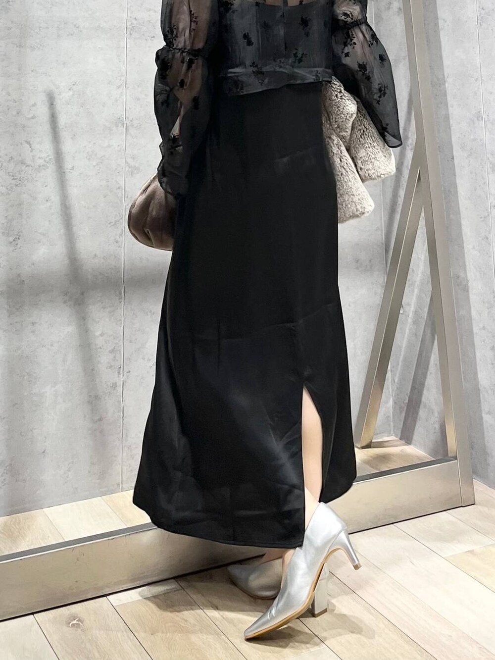 シルバー系のパンプス、ブラウン系のハンドバッグ、ベージュ系のノーカラーコートを着用したレディースの秋コーディネートの5枚目の写真