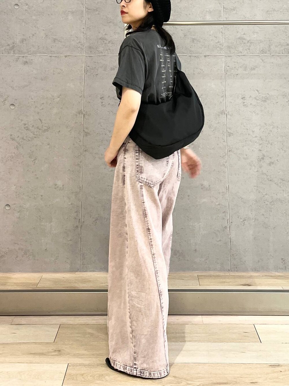 パープル系のデニムパンツ、ブラック系のショルダーバッグ、ブラック系のTシャツ/カットソーを着用したレディースの春コーディネートの7枚目の写真