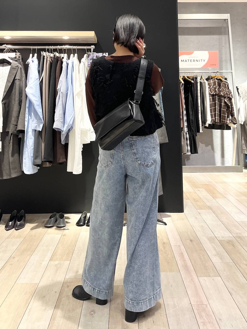 ブルー系のデニムパンツ、ブラック系のショルダーバッグ、ブラック系のその他シューズを着用したレディースの秋コーディネートの4枚目の写真