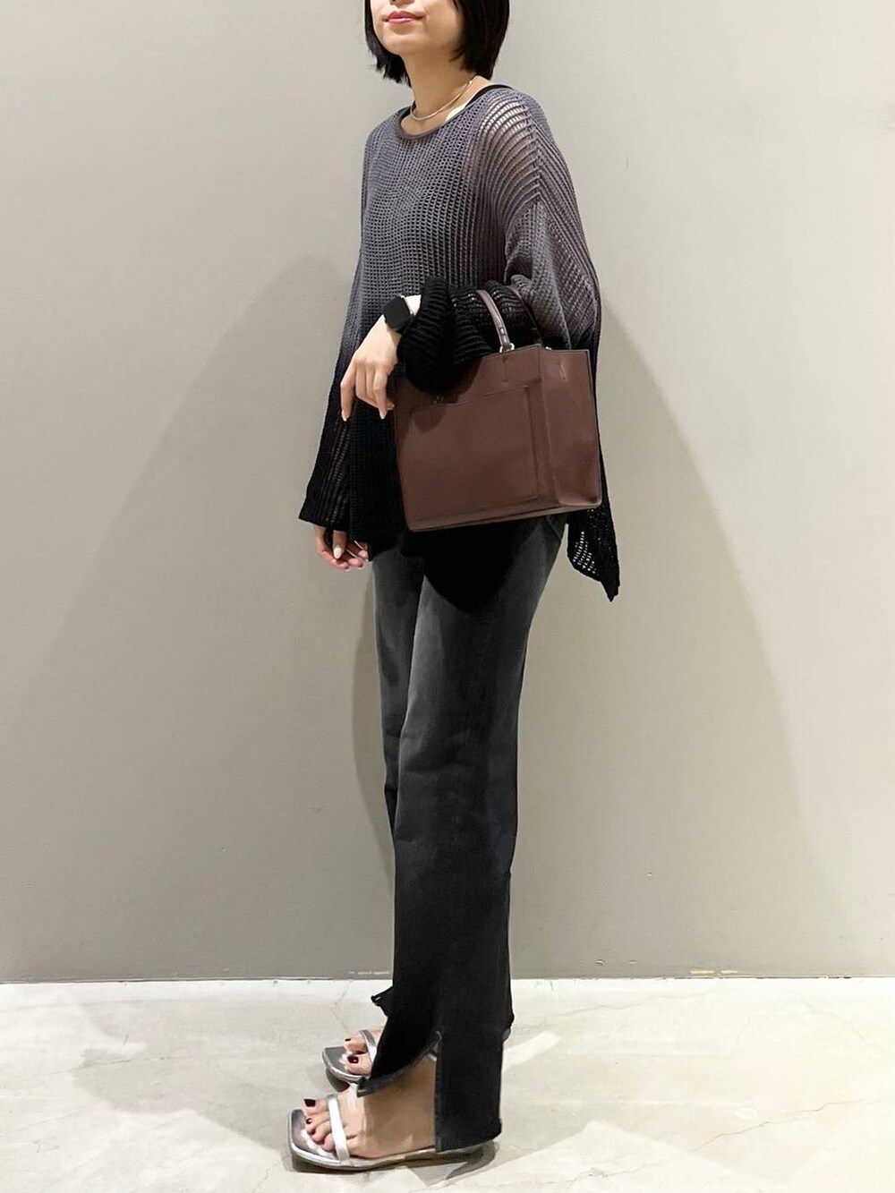 ブラック系のニット/セーター、シルバー系のサンダル、ブラック系のデニムパンツを着用したレディースの夏コーディネートの3枚目の写真