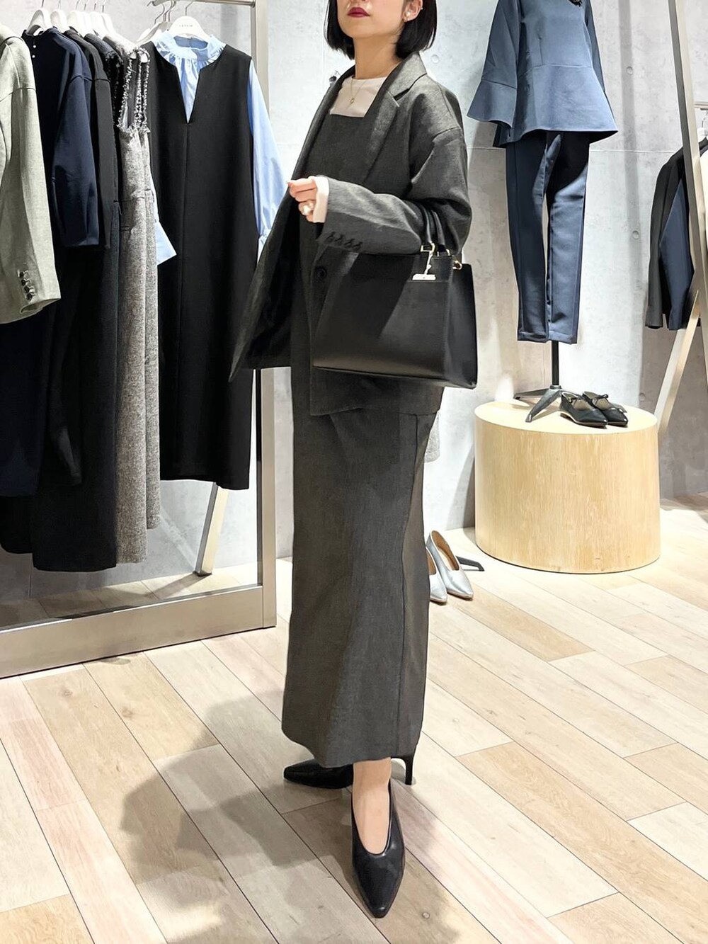 ホワイト系のTシャツ/カットソー、ブラック系のパンプス、ブラック系のショルダーバッグを着用したレディースの冬コーディネートの3枚目の写真