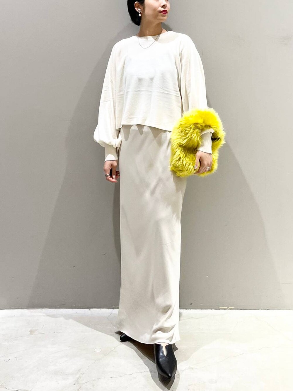 ブラック系のキャミソール、ホワイト系のニット/セーター、イエロー系のハンドバッグを着用したレディースの秋コーディネートの8枚目の写真