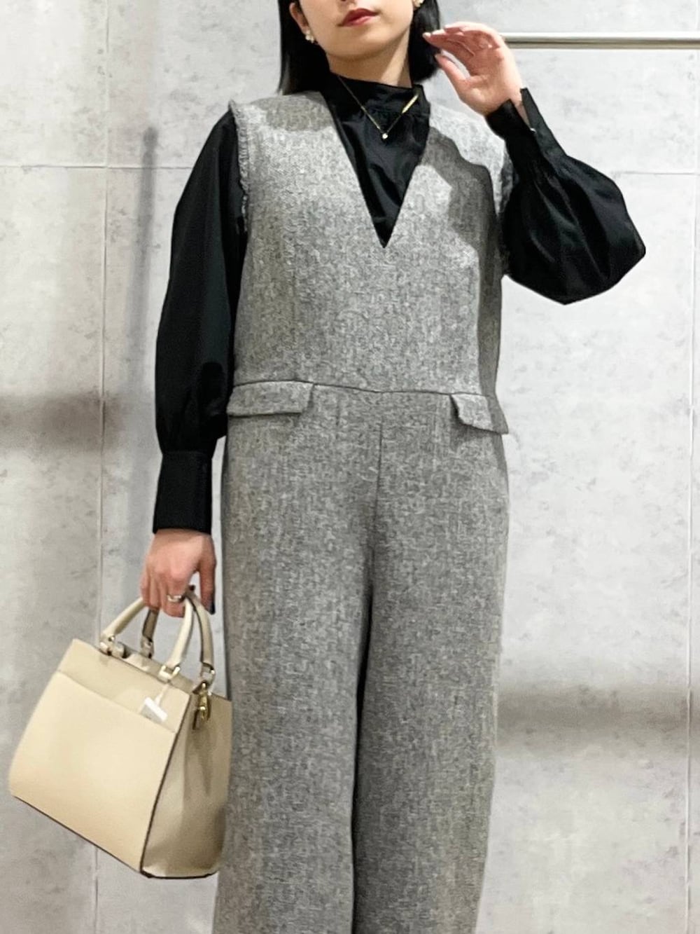 ブラック系のパンプス、ホワイト系のサロペット/オーバーオール、ブラック系のシャツ/ブラウスを着用したレディースの冬コーディネートの2枚目の写真