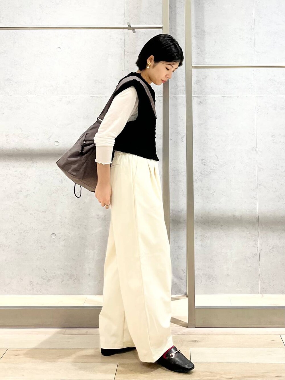 ブラック系のローファー、ホワイト系のTシャツ/カットソー、ブラック系のベストを着用したレディースの秋コーディネートの8枚目の写真