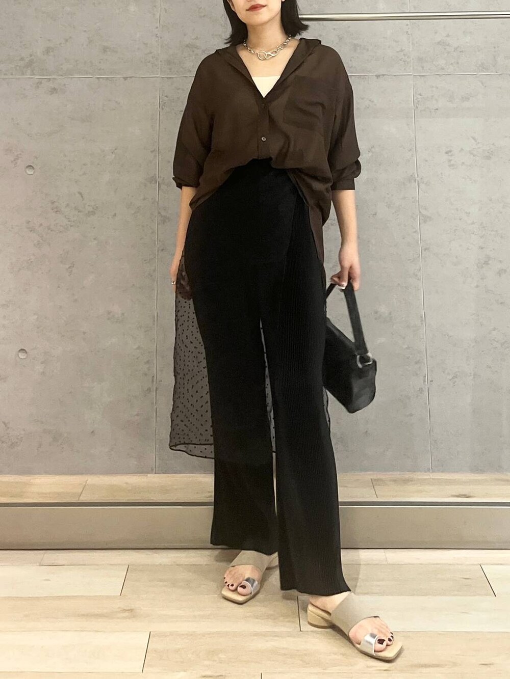 ホワイト系のタンクトップ、ブラック系のハンドバッグ、ブラック系のその他パンツを着用したレディースの夏コーディネートの3枚目の写真