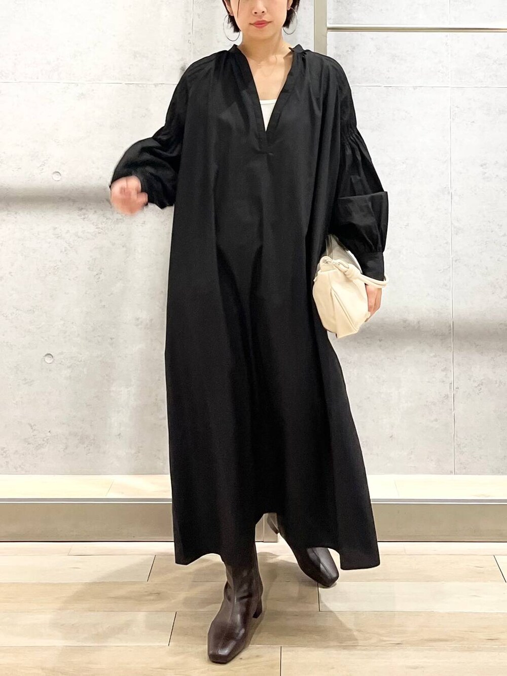 ホワイト系のキャミソール、ブラック系のワンピース、ホワイト系のショルダーバッグを着用したレディースの秋コーディネートの3枚目の写真