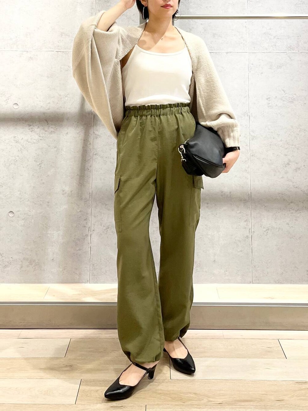 ホワイト系のキャミソール、ベージュ系のカーディガン/ボレロ、グリーン系のカーゴパンツを着用したレディースの秋コーディネートの2枚目の写真