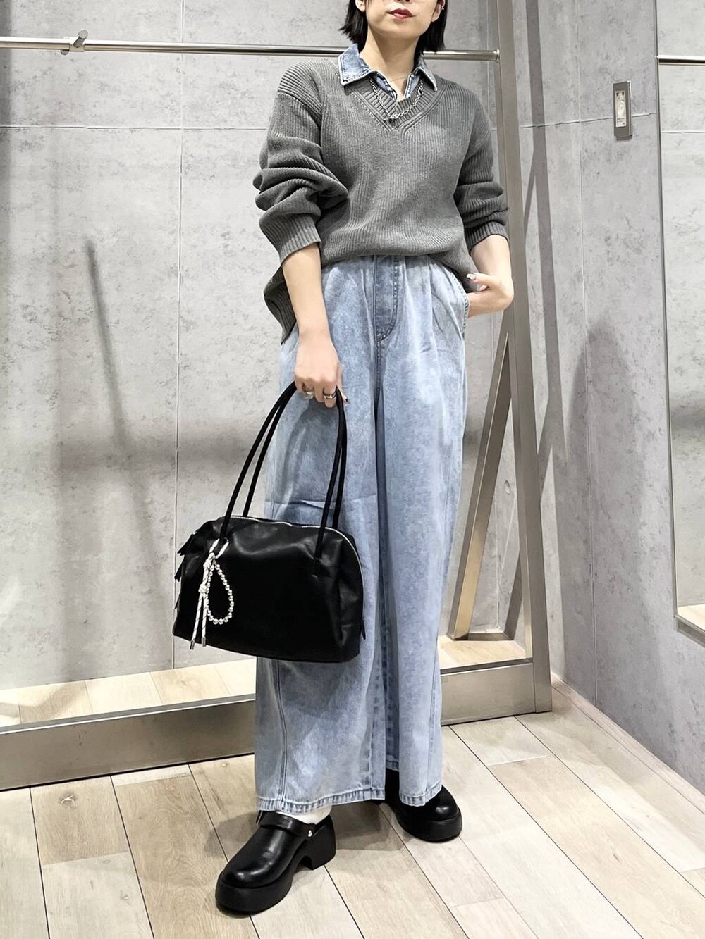 ブラック系のサンダル、ブルー系のデニムパンツ、ブラック系のボストンバッグを着用したレディースの冬コーディネートの5枚目の写真