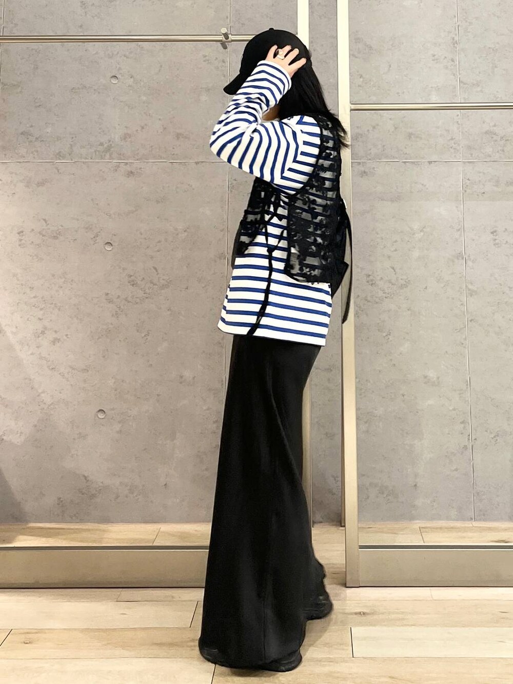 ブラック系のスカート、ブルー系のTシャツ/カットソー、ブラック系のスニーカーを着用したレディースの冬コーディネートの4枚目の写真