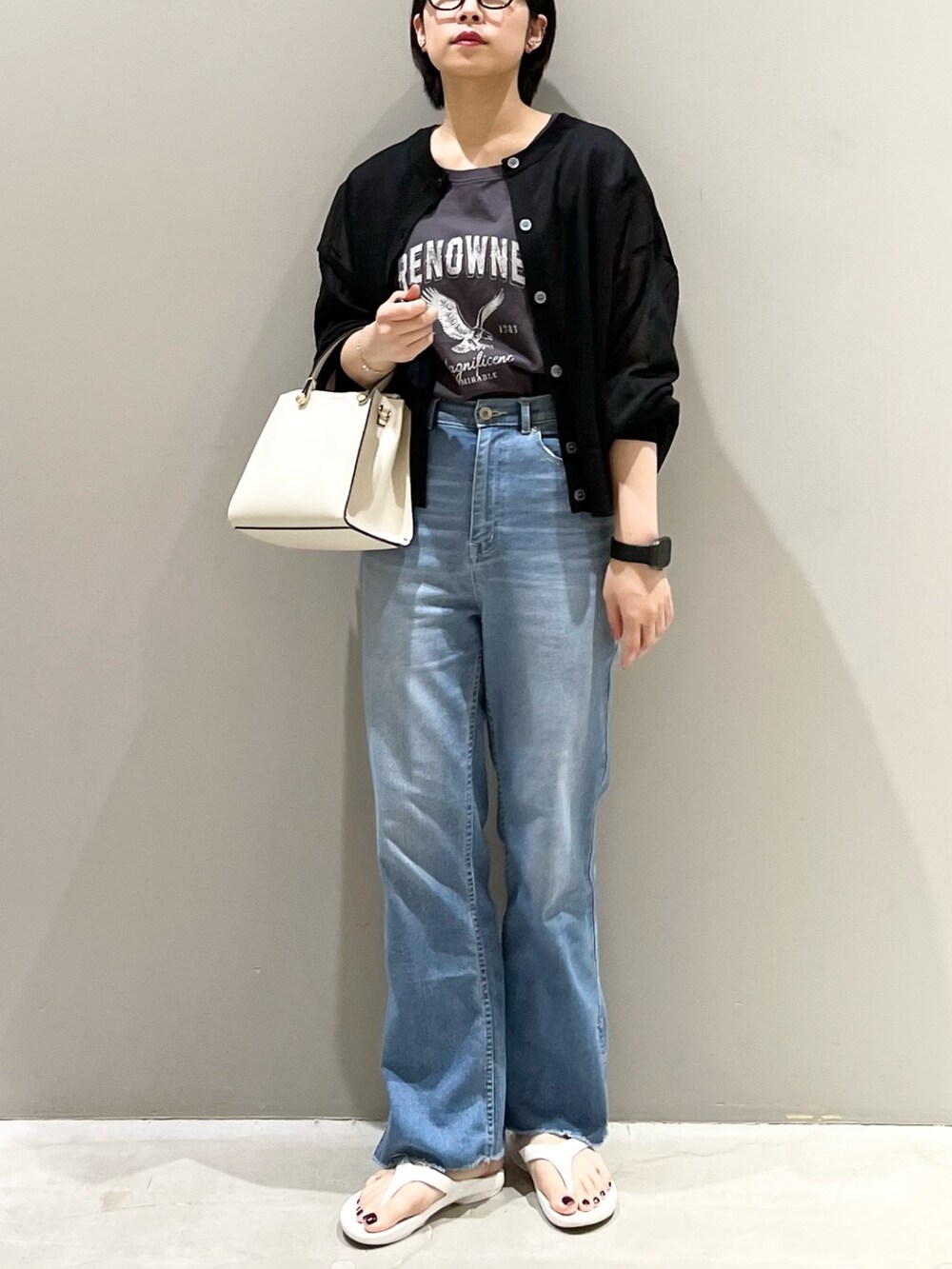 ホワイト系のサンダル、ホワイト系のショルダーバッグ、ブルー系のデニムパンツを着用したレディースの夏コーディネートの2枚目の写真