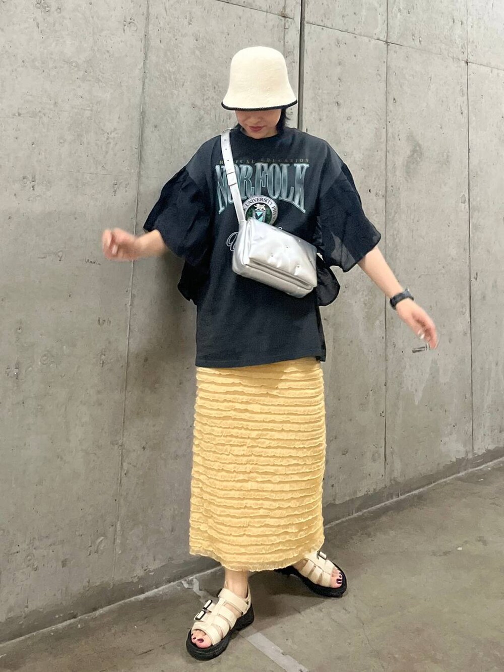 ベージュ系のスカート、シルバー系のショルダーバッグ、ホワイト系のサンダルを着用したレディースの春コーディネートの6枚目の写真