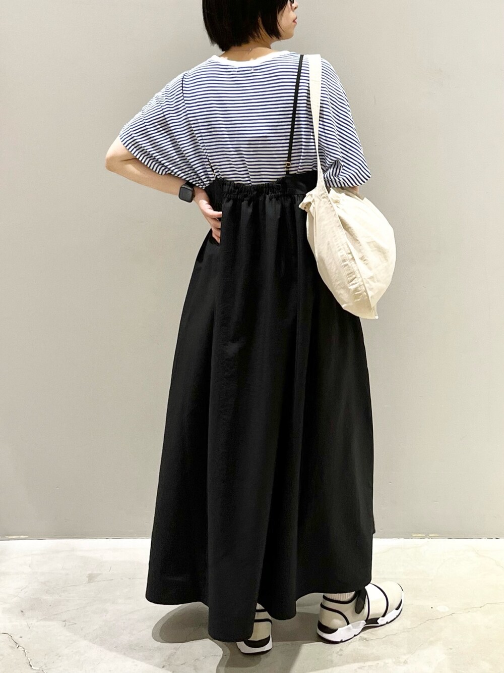 ブラック系のワンピース、ブルー系のTシャツ/カットソー、ホワイト系のショルダーバッグを着用したレディースの秋コーディネートの4枚目の写真