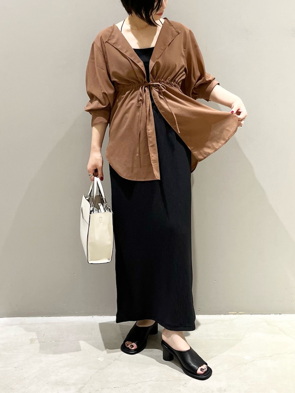 イエロー系のシャツ/ブラウス、ブラック系のスカート、ブラウン系のバッグを着用したレディースの秋コーディネートの2枚目の写真