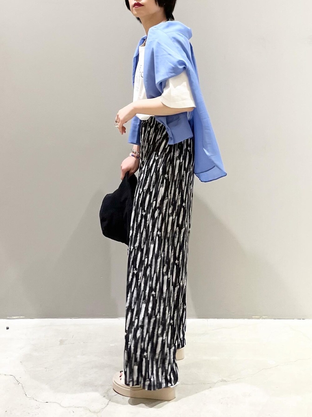 ブラック系のその他パンツ、ベージュ系のサンダル、ホワイト系のTシャツ/カットソーを着用したレディースの春コーディネートの5枚目の写真